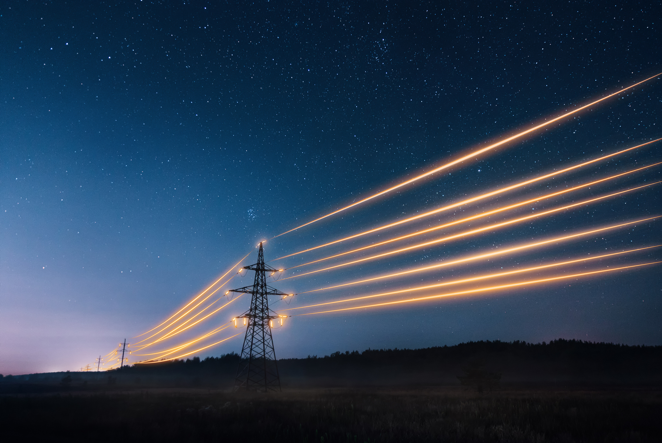 Electricity transmission towers with orange glowing wires the starry night sky. Energy infrastructure concept.